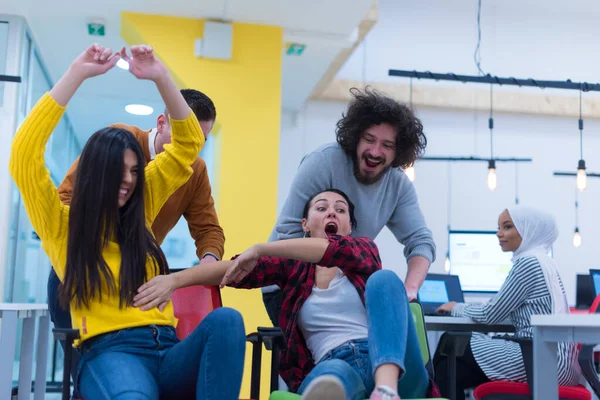 Genç iş adamları ofiste sandalyeye biniyor.