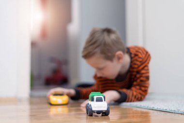 Boy playing toy cars. Kid with toys. Child and car at home
