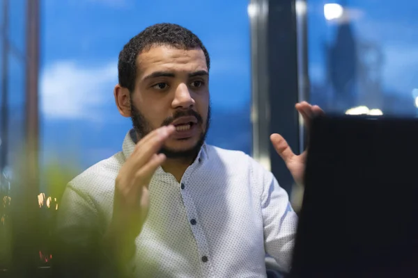 Virtual meeting with many people together. African-American young guy talking online with employees via video connection