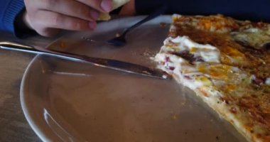 Kafede oturan ve pizza yiyen adam, yakın çekim görüntüleri.