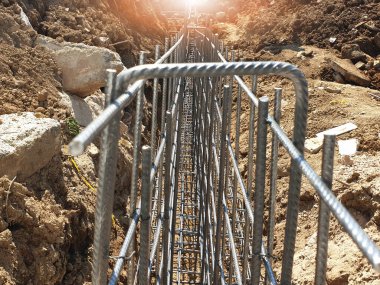 İnşaat işçileri inşaat alanında çelik takviye çubuğu üretiyorlar.