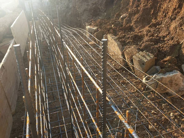 İnşaat işçileri inşaat alanında çelik takviye çubuğu üretiyorlar.