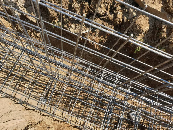 İnşaat işçileri inşaat alanında çelik takviye çubuğu üretiyorlar.