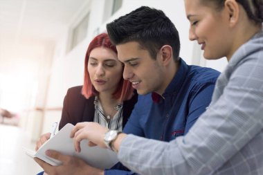 Üniversitedeki dersten sonra çok ırklı öğrenciler sohbet ediyorlar.