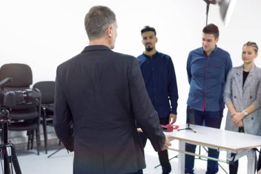 Bilgisayar laboratuvarında video kameralı öğrenciler, stüdyoda çekim yapıyorlar. Pratik dersleri.