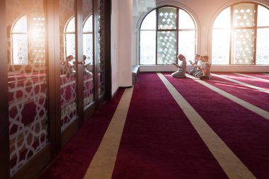 Minnettar bir kalple dua et. Bir grup dindar Müslüman genç insan güzel modern camide birlikte dua ediyor.