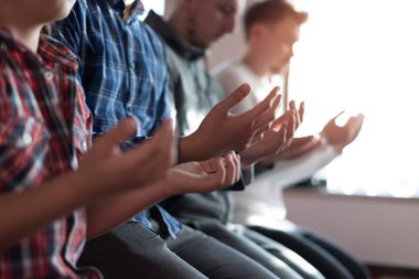 Minnettar bir kalple dua et. Bir grup dindar Müslüman genç insan güzel modern camide birlikte dua ediyor.