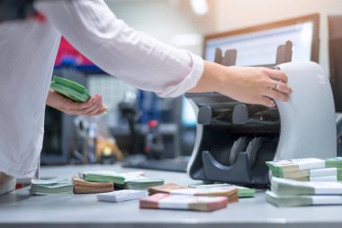 Bankada büyük miktarda para var. Banka çalışanları banka kasasında para sıralayıp sayıyor.