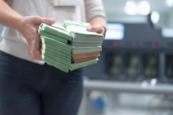 Large amounts of money in the bank. Bank employees sorting and counting money inside bank vault.