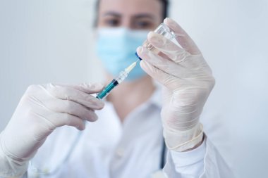Female doctor preparing syringe. Beautiful nurse preparing a syringe