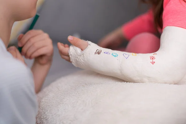 River fracture in a child. Brother and sister draw on plaster, bandages.