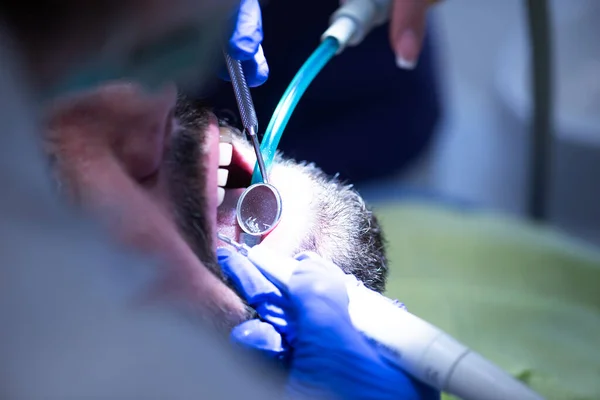 Jovem Dentista Feminina Segurando Instrumentos Dentários Enquanto Trabalhava Com Paciente — Fotografia de Stock