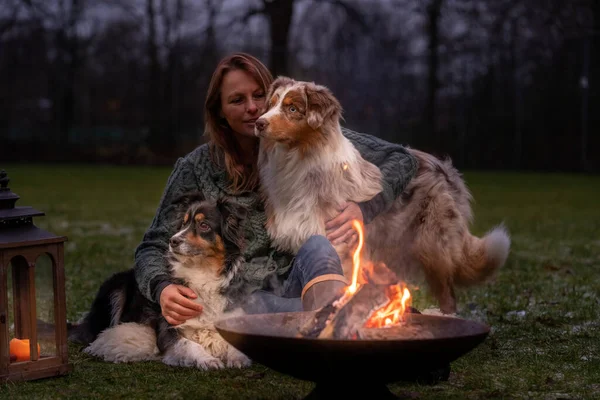 Genç Bir Kadın Iki Avustralya Çoban Köpeğiyle Birlikte Ormanda Oturuyor — Stok fotoğraf