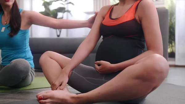 妊娠中の女性は自宅でパーソナルトレーナーと一緒にピラティス運動をする — ストック写真