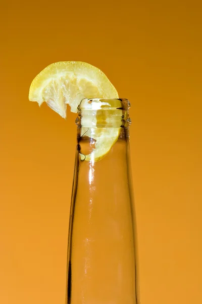 Bouteille avec morceau de citron — Photo
