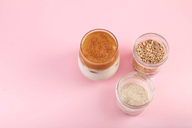 Dalgona Misugaru Latte - Kore ferahlatıcı içeceği. Popüler kahvaltı içeceği ve hazır kahve. Pembe arkaplan, kopyalama alanı.