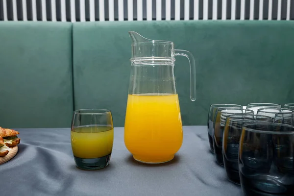 Glas Frischer Orangensaft Und Großer Krug Fruchtgetränk Auf Grauem Tisch — Stockfoto