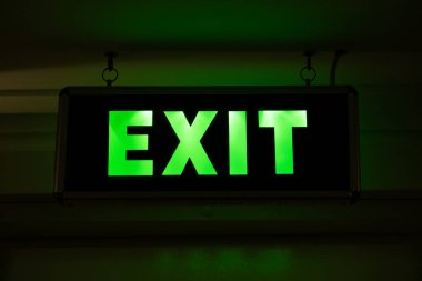 Üzerinde EXIT yazan neon levhası. Tahliye sırasında karanlık bir odada veya boşlukta hareket göstergesi.