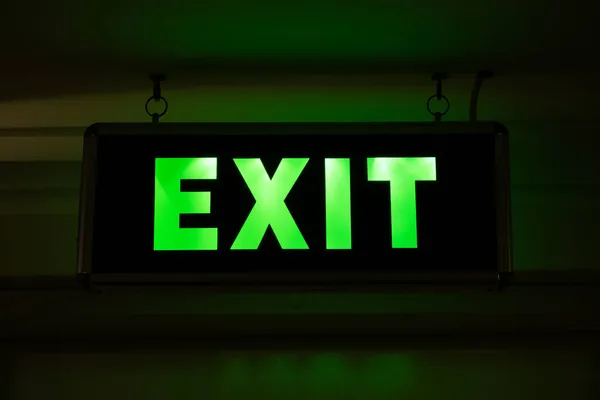 Üzerinde EXIT yazan neon levhası. Tahliye sırasında karanlık bir odada veya boşlukta hareket göstergesi.