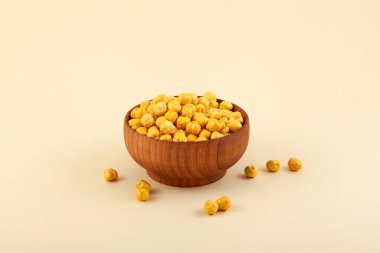 Bej arka planda ahşap kasede kızarmış nohut ya da Leblebi. Türk yemeği. Seçici odak, boşluğu kopyala.