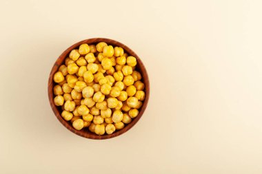 Leblebi, kavrulmuş nohut, ahşap kasede bej arka planda, üst manzara. Türk yemeği. Seçici odak, boşluğu kopyala.