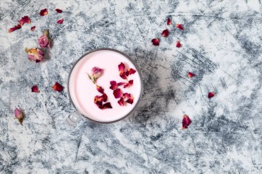 Gri desenli arka planda pembe ay sütü, üst manzara, seçici odak. Gece yarısı içeceği güllerle rahatlatıcı.