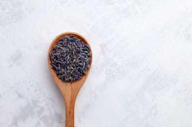 Ahşap kaşıkta lavanta tohumları, yakın plan. Üst görünüm, boşluğu kopyala. Saf organik çiçekler ve doğal keseler ya da parfüm kompozisyonları yaratmak için aromatik tütsü..