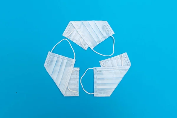リサイクルシンボルはフェイスマスクで作られています コンセプト 医療用ゴミ Covid 19コロナウイルスのパンデミックによる廃棄物処理の問題 環境保護 — ストック写真