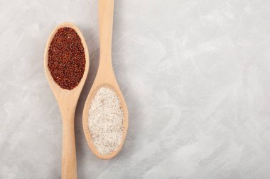 Ragi ya da Nachni, ayrıca parmak darı olarak da bilinir ve tahta kaşıklardaki ragi kabuklu un gri desenli masada. Üst görünüm, alanı kopyala.