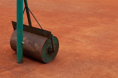 Suyla dolu buz pateni pisti. Asfaltsız tenis kortunu örtmek için ağır bir alet. Seçici odak.