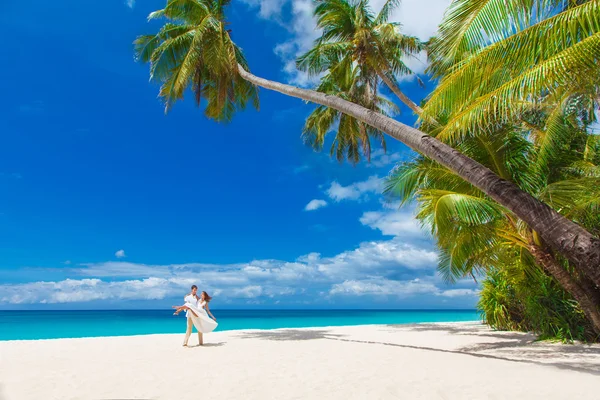 Joven pareja amorosa en la playa tropical con palmeras, boda o —  Fotos de Stock