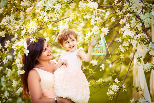 Mujer feliz y niño en el floreciente jardín de primavera.Día de las Madres —  Fotos de Stock