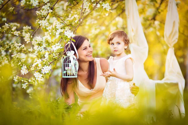 Happy woman and child in the blooming spring garden.Child kissi — Stock Photo, Image