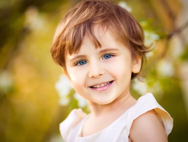 Happy little girl having fun in the blooming spring garden — Stock Photo, Image