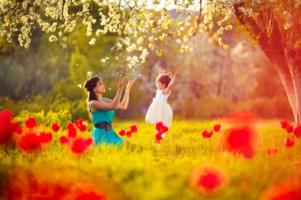 Glückliche Frau und Kind im blühenden Frühlingsgarten. Muttertag — Stockfoto