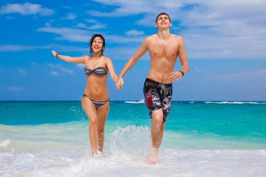 Kumsalda koşan mutlu çift