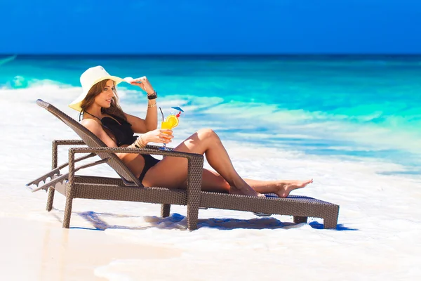 Mujer joven en sombrero de paja que pone en la playa tropical y enjoyi —  Fotos de Stock