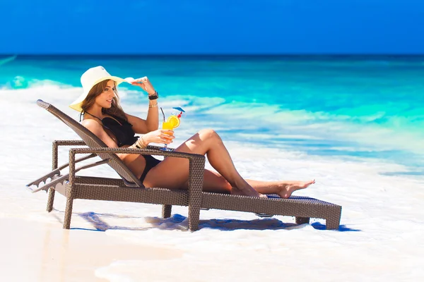 Young woman in straw hat laying at the tropical beach and enjoyi — Stock Photo, Image