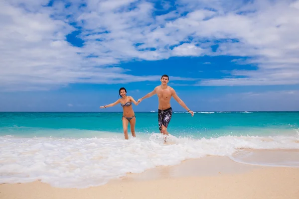 幸福的夫妻在海滩上奔跑 — 图库照片