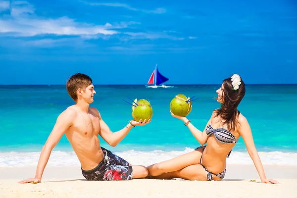 Giovane coppia felice amante sulla spiaggia tropicale, con noci di cocco — Foto Stock