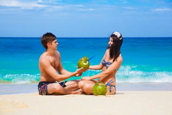 Jovem casal feliz amoroso na praia tropical, com cocos — Fotografia de Stock