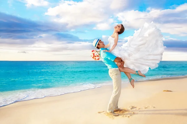 Gelukkige bruid en bruidegom plezier op een tropisch strand — Stockfoto