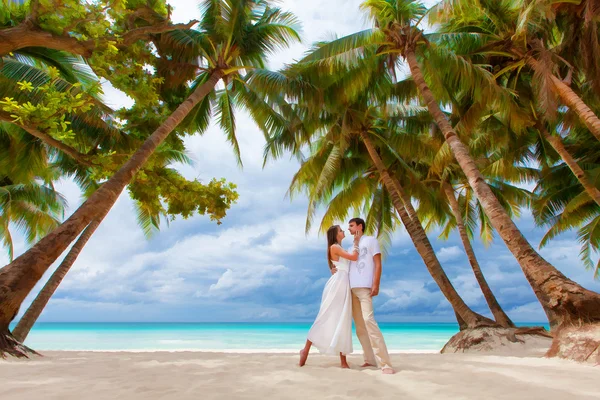 Joven pareja amorosa en la playa tropical con palmeras, boda o —  Fotos de Stock