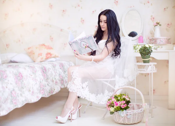 Hermosa novia joven en un vestido blanco con un ramo de boda de — Foto de Stock