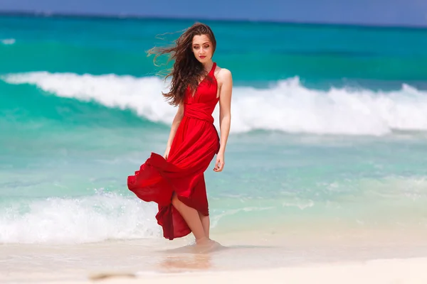 一件红色的连衣裙站在热带海区 co 上美丽的女人 — 图库照片