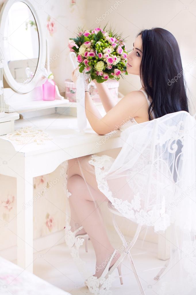 beautiful young bride in a white dress with a wedding bouquet of