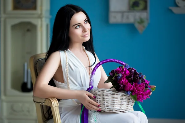 Hermosa joven morena en vestido blanco y un collar de perlas sentarse — Foto de Stock