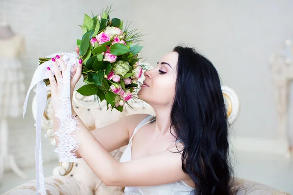 Bella giovane sposa in un abito bianco con un bouquet da sposa di — Foto Stock