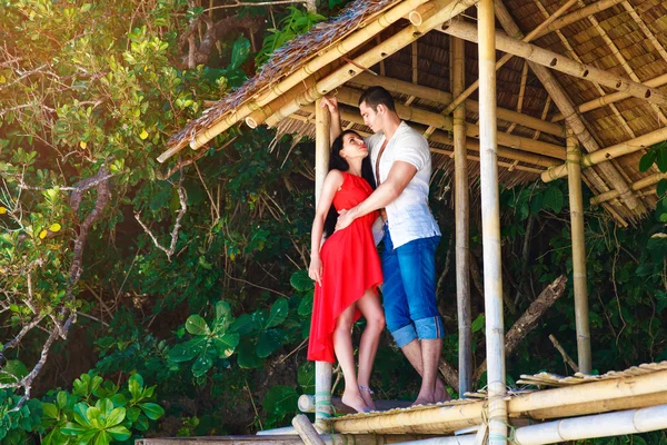 Young beautiful loving couple in tropical hut — Stock Photo, Image