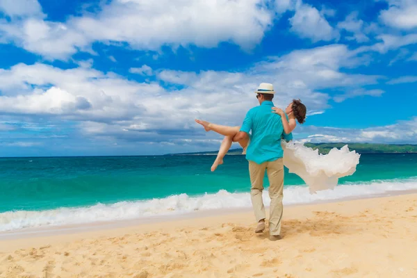 Mariée heureuse et marié s'amusant sur une plage tropicale — Photo
